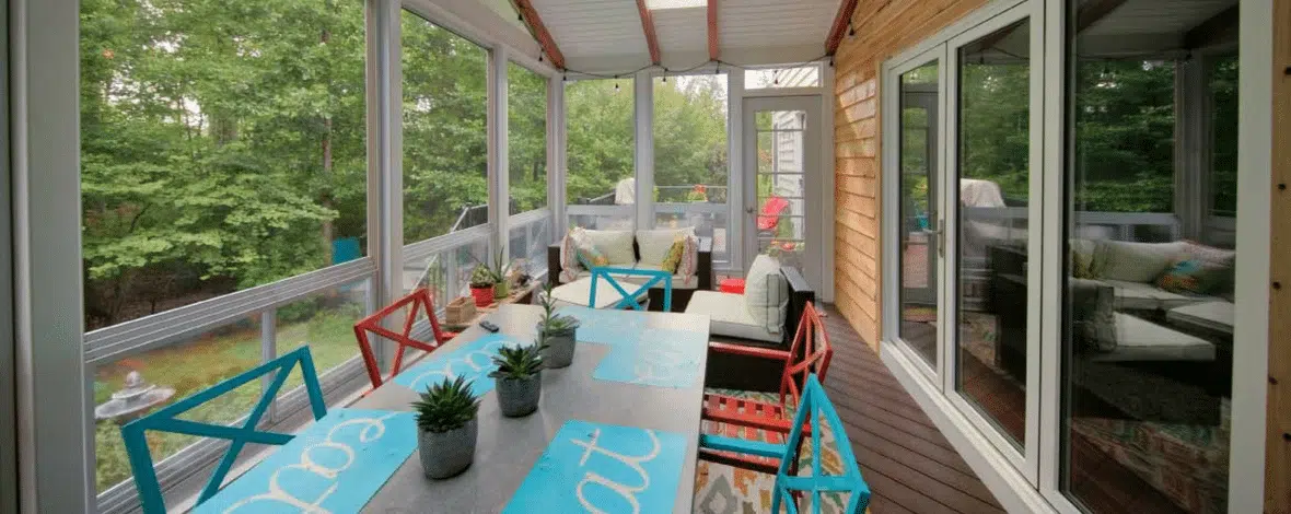 Outdoor covered patio space with raised ceilings and wood siding by Deck Creations.