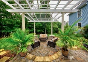 Custom White Pergola and Earthy Hardscape Patio Designed by Deck Creations.