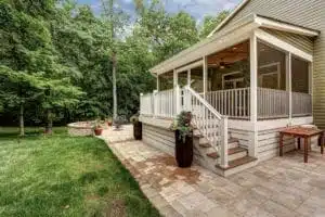 Custom screen porch with horizontal skirting, Timbertech decking, and a belgard patio and fire pit.