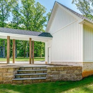 White Siding Building with a Covered Stone Walkway built by Deck Creations.