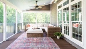 Gorgeous screened porch design with dark wood floors, white wood trim and ceilings, and open views of the backyard.