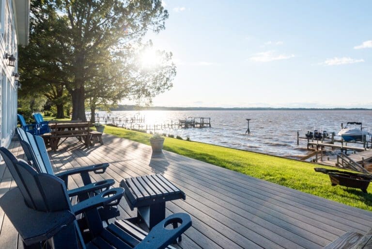 A breathtaking back deck designed and built by Deck Creations, offering stunning views of the water, backyard, and docks.