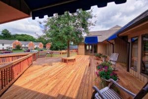 A grand wooden porch and accessible ramp, meticulously crafted by Deck Creations.