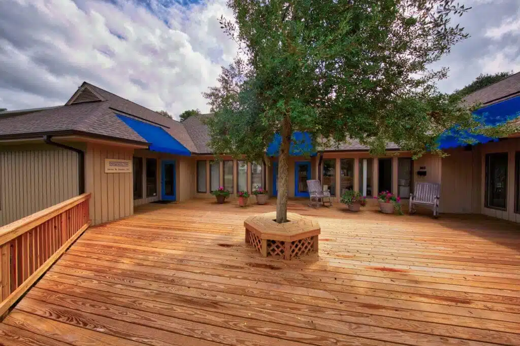 A grand wooden porch and accessible ramp, meticulously crafted by Deck Creations.