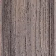 Close-up of a weathered deck surface, showcasing textured wood with vertical grooves and varying shades of gray and brown.