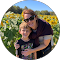 A woman and child embrace the essence of outdoor living as they stand smiling in a vibrant sunflower field, capturing a moment of pure joy.