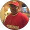 A person wearing a red 49ers cap and matching shirt stands in a kitchen, blending effortlessly with the vibrant backdrop like siding on a freshly painted house.