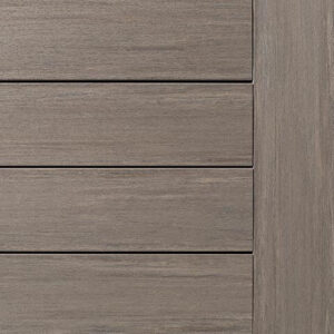Close-up of a wooden deck surface with horizontal panels and a vertical edge, featuring a grayish-brown texture and subtle grain patterns.