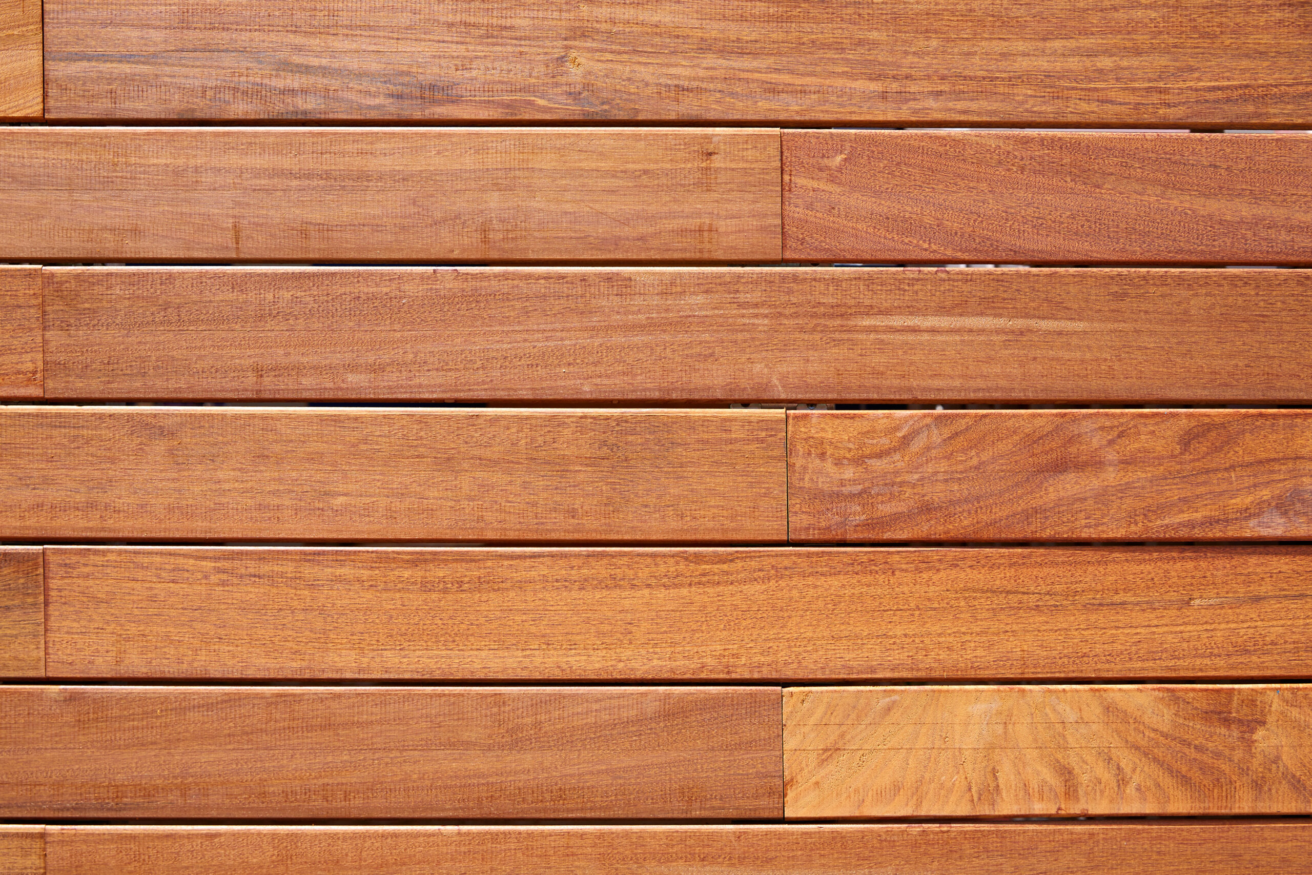 Close-up of a deck with horizontal slats, showcasing a smooth, polished surface and a warm, brown color.