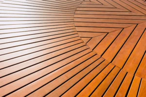 The deck features a stunning geometric pattern, with wooden planks arranged in a circular design that showcases alternating light and dark wood tones.