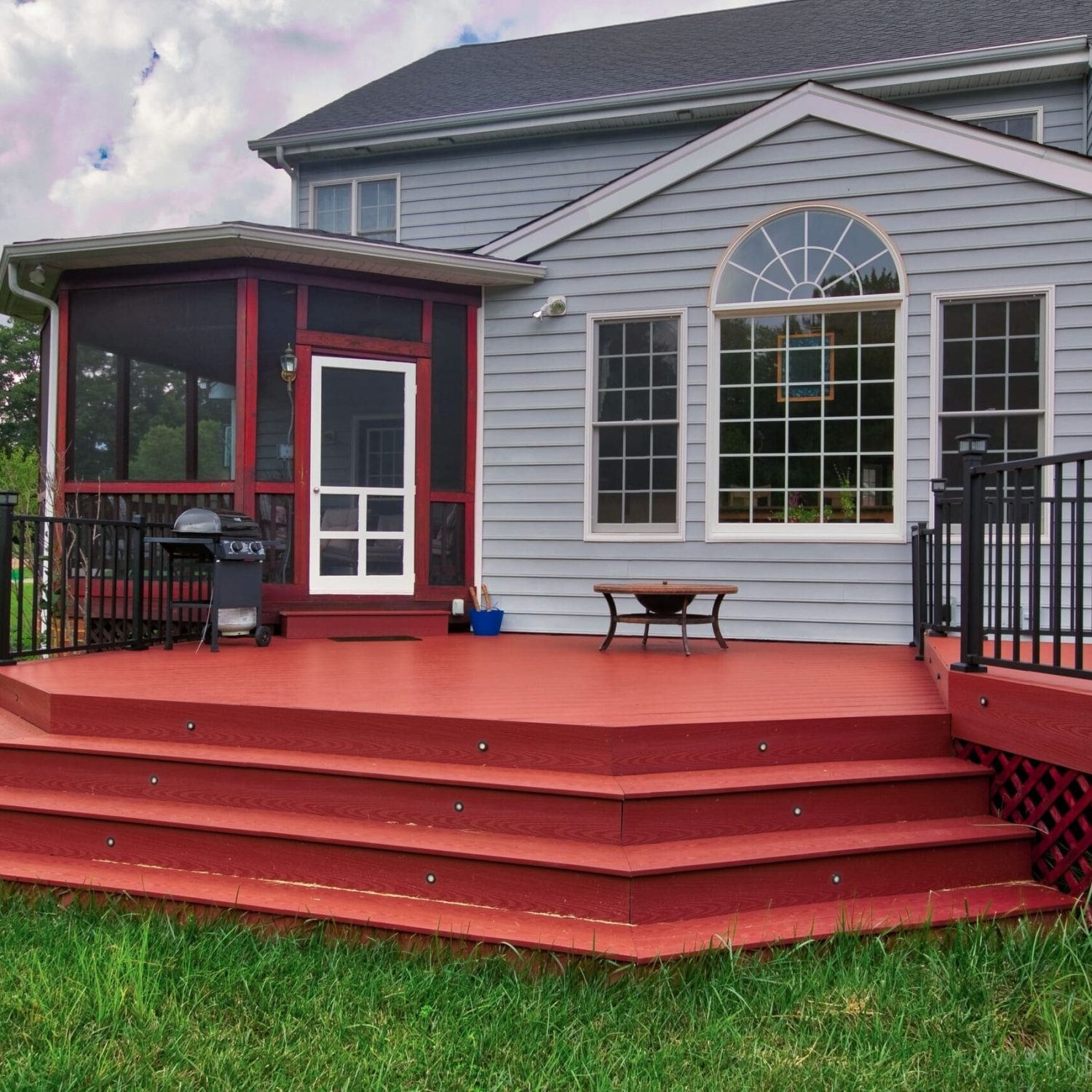 House with Gray Vinyl Siding, Covered Porch and a Custom Red Wood Deck built by Deck Creations.